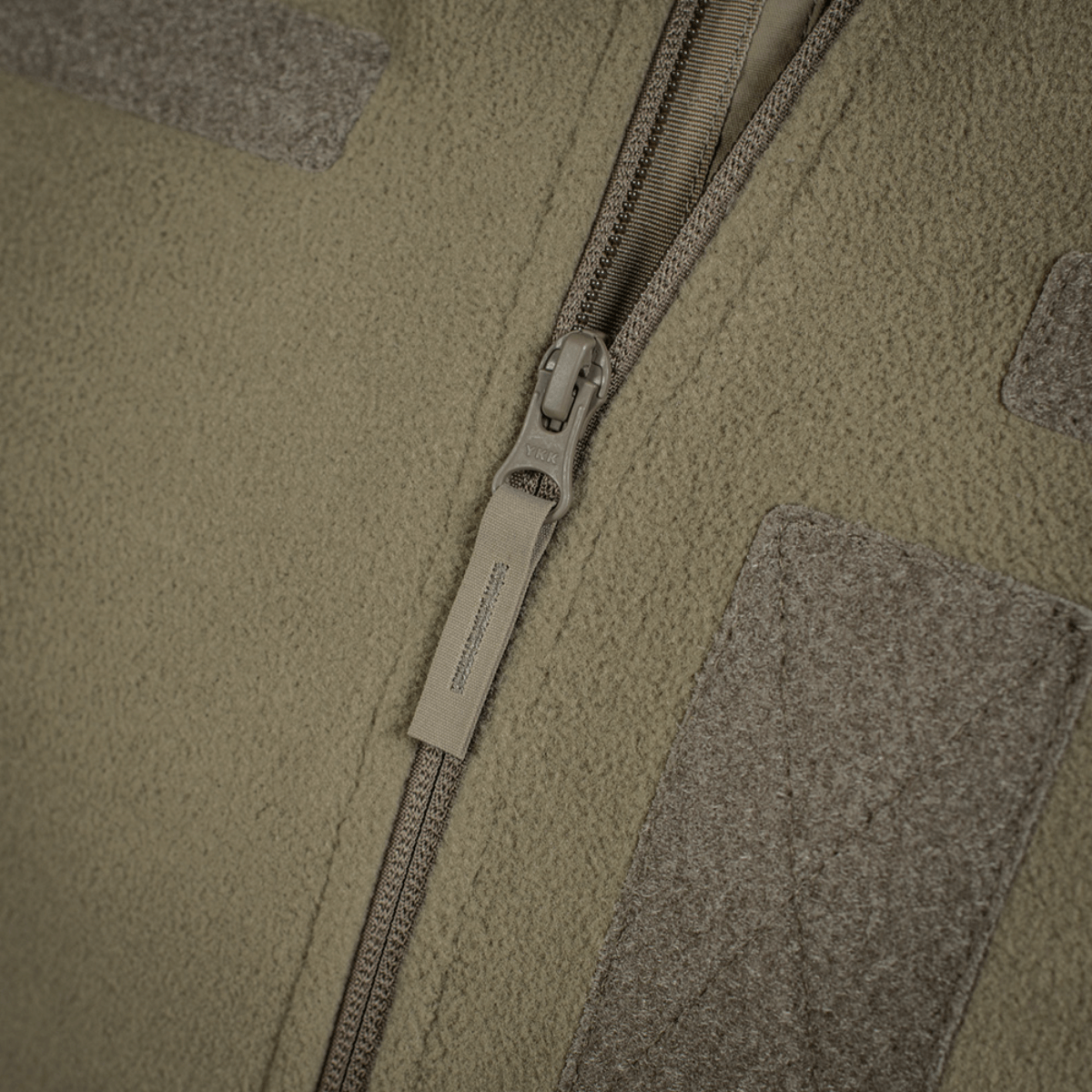 Yksityiskohta vetoketjusta M-Tac Combat Fleece Polartec -takissa; takki taktiseen käyttöön, vihreä vetoketjullinen malli.