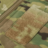 M-Tac Alpha Gen.IV Pro Primaloft -talvitakin yksityiskohta Multicam-kankaalla ja vetoketjulla. Sopii suojaukseen jopa -20°C. Jakob-merkki ja taskuosa.