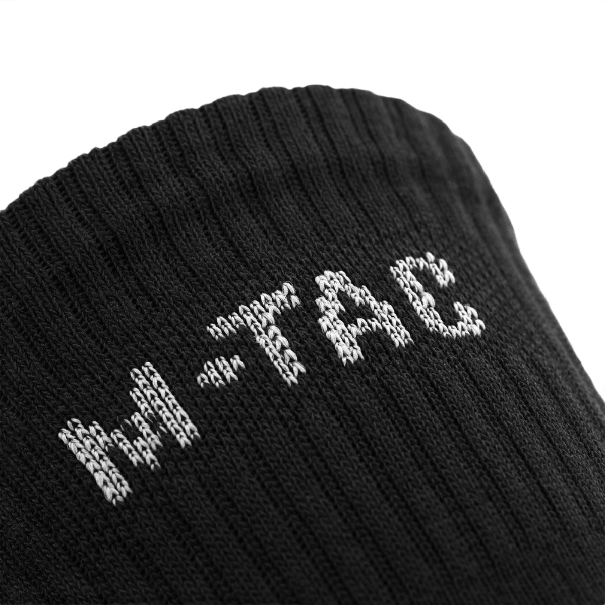 Lähikuva M-Tac Høje Sokker Mk.2 -sukista logolla, suunniteltu tukea ja mukavuutta varten trekkingissä.