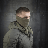 M-Tac Polartec Anatomic Tube Scarf käytettynä kasvomaskina metallitaustaisessa ympäristössä, näyttää monipuolisuutta ja tyyliä.