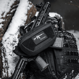 M-Tac AR-15 223/5,56 Laser Cut Patch, kiinnitetty taktiseen laukkuun lumisessa ympäristössä, kestävä patch sotilaalliselle, airsoft- ja ulkoilmakäyttöön, Velcro-kiinnitys.