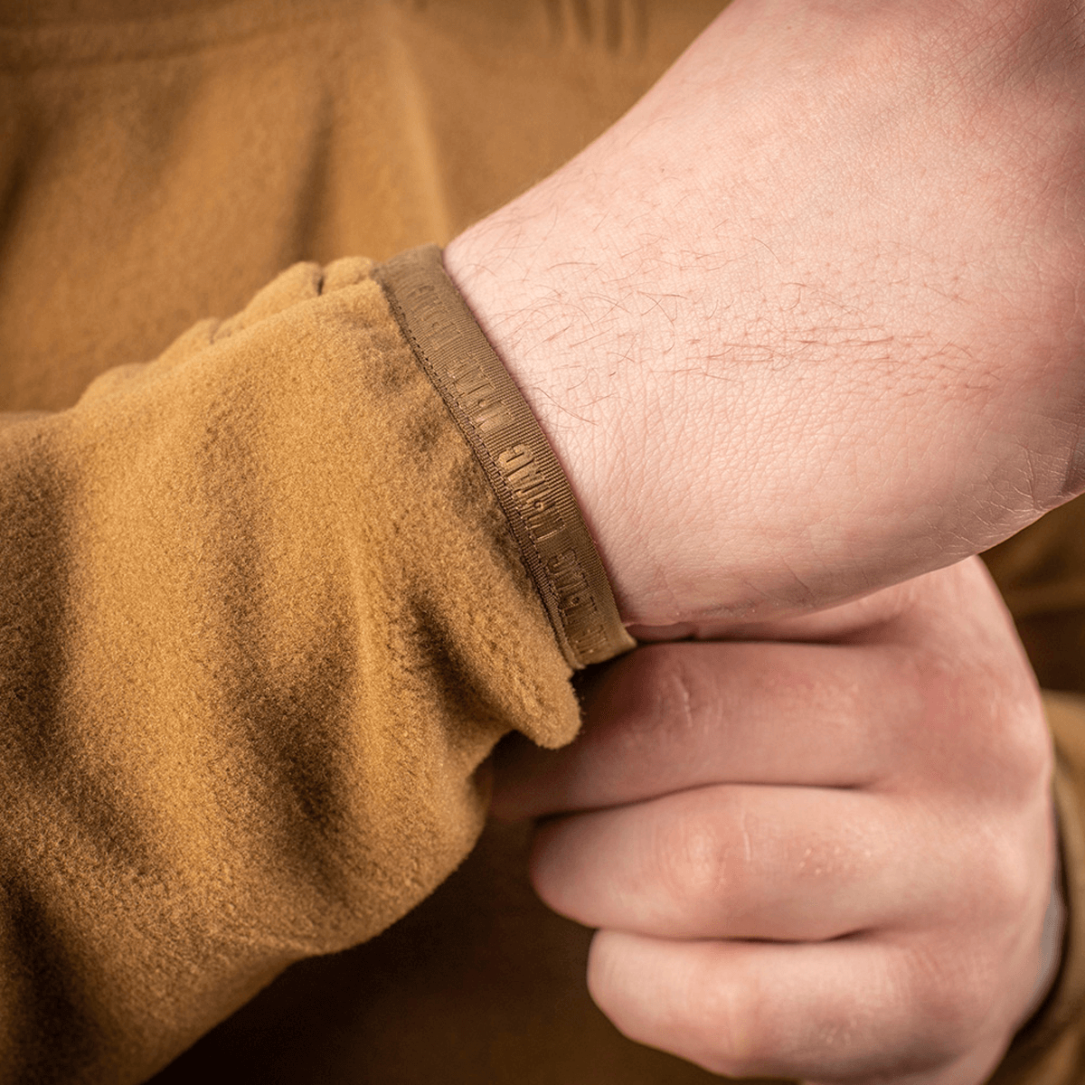 Lähikuva hihasta M-Tac Delta Polartec fleece-takissa ruskeana, näyttää takin yksityiskohtaisen Polartec-kankaan.