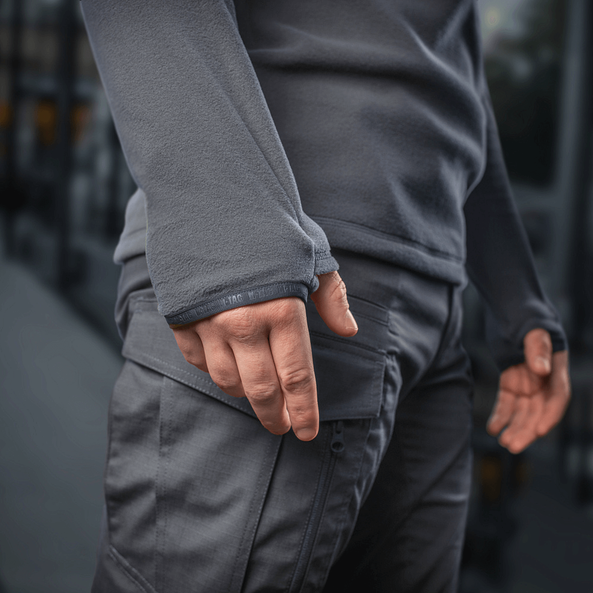 Mies pukeutuneena M-Tac Delta Polartec -fleece-takkiin; näkyy taskun yksityiskohta.
