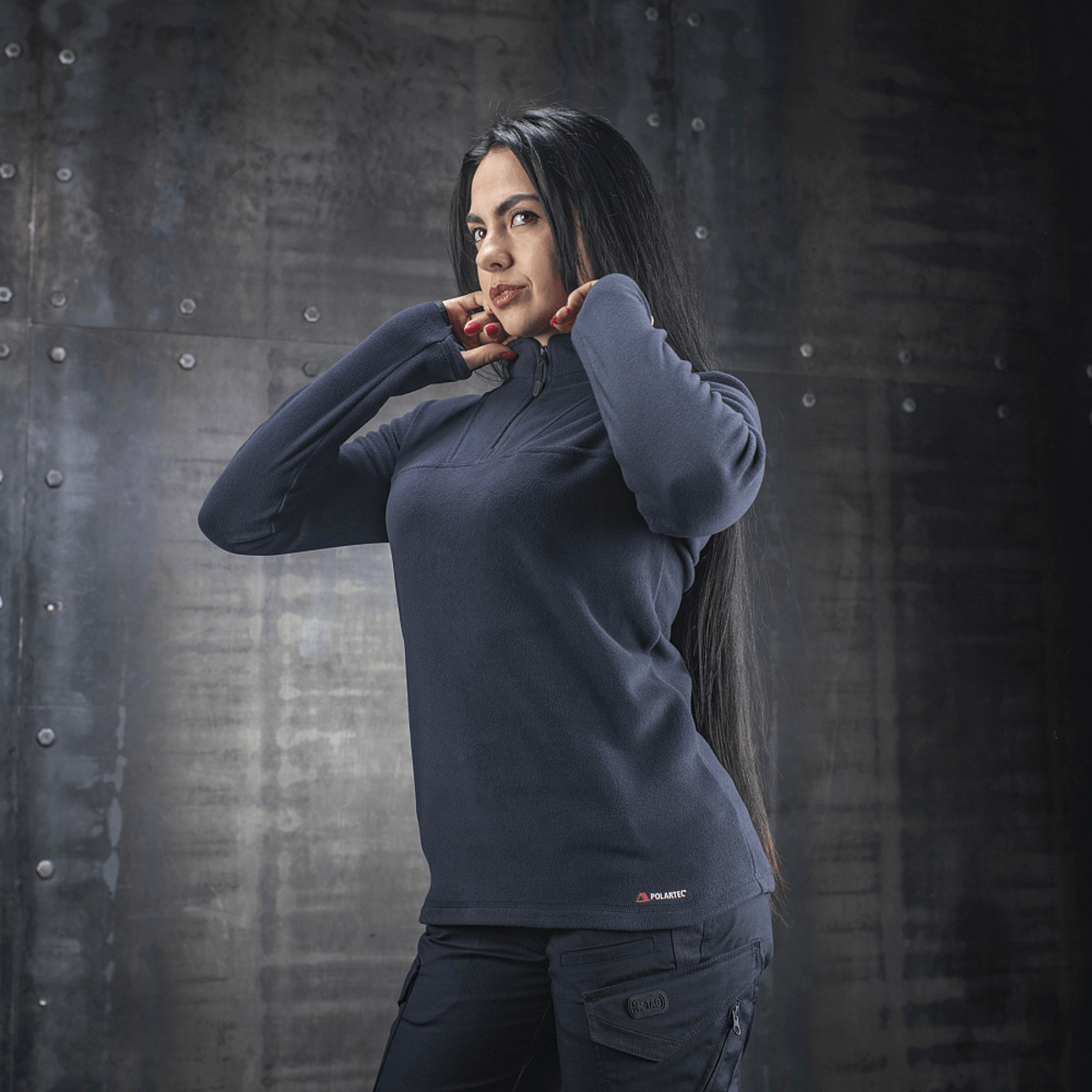 Nainen pukeutuneena M-Tac Delta Polartec -naisten fleece-takkiin tummansinisenä, valmistettu Polartec® Micro Series -fleecestä mukavuutta ja lämpöä varten.