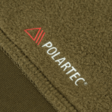 Lähikuva M-Tac Polartec Sport -hupparista, näyttää Polartec®-logon, viitaten lämmöneristykseen ja hengittävään mukavuuteen.