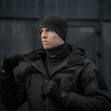 Mies käyttää M-Tac Tube Scarf Polartec Power Grid -kauluria, musta, suojaa kylmältä ja tuulelta ulkokäytössä.