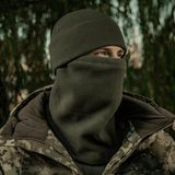 Mies pukeutuneena M-Tac Anatomisk Snood Justerbar Elite Fleece (320 g/m²) metsässä, erinomainen kylmään säähän.