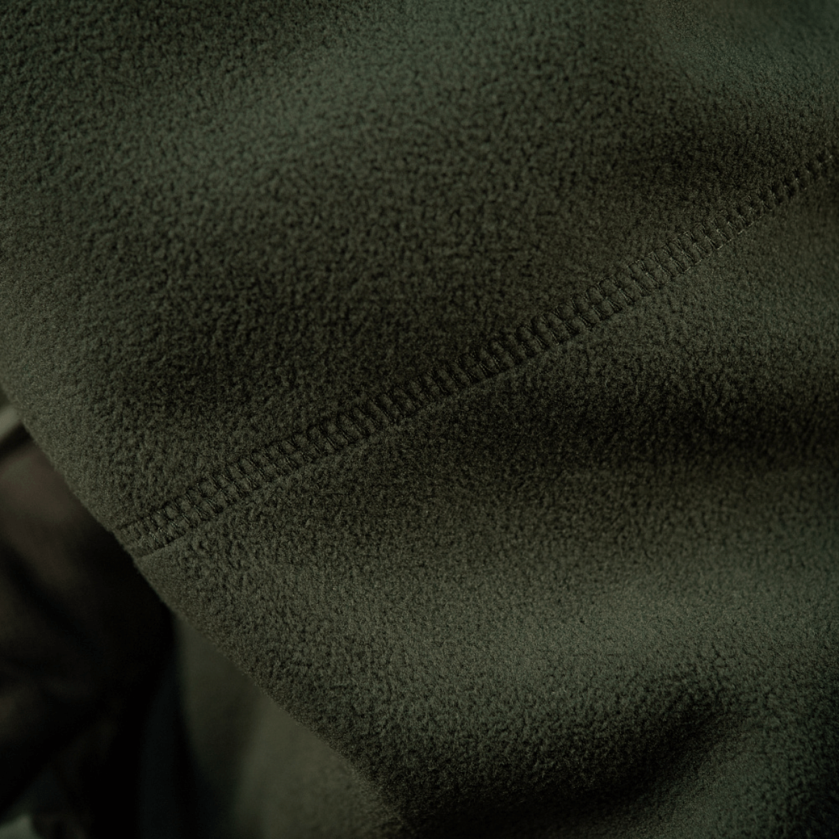 Lähikuva M-Tac Anatomisk Snood Justerbar Elite Fleece (320 g/m²) yksityiskohdista pehmeässä vihreässä fleecessä ja saumoista.