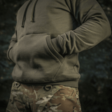 M-Tac Cotton Raglan Hard Hoodie fleece-vuorella, raglan-hihoilla ja kengurutaskulla kamuflaasitaustalla. Sopii syksyyn ja talveen.