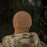 M-Tac Rip-Stop Fleece Hjelmliner luonnonympäristössä maastokuvioisen takin kanssa, sopii kylmiin olosuhteisiin