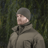 Mies pukeutuneena M-Tac Fleece Polartec Watch Cap -pipoon metsässä, sopii ulkoiluun ja talvikäyttöön.
