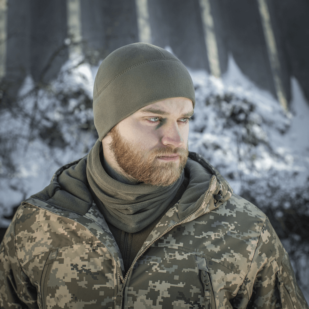 Mies pukeutuneena M-Tac Fleece Watch Cap Light Polartec talvimaisemassa.