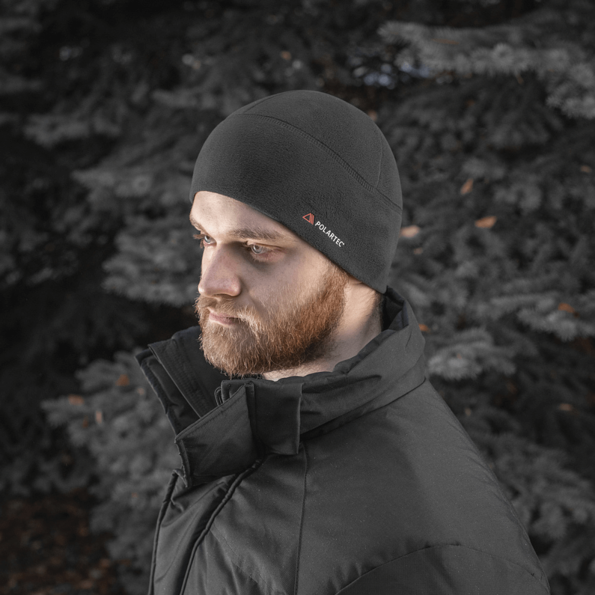 Mies pitää M-Tac Fleece Watch Cap Light Polartec, monikäyttöinen talvihattu, valmistettu Polartec Micro Series fleece -materiaalista, sopii talvikäyttöön.