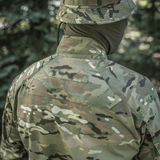 M-Tac-takki Sturm Gen.II NYCO Extreme Multicam takaa kuvattuna metsäympäristössä, taktiseen käyttöön.