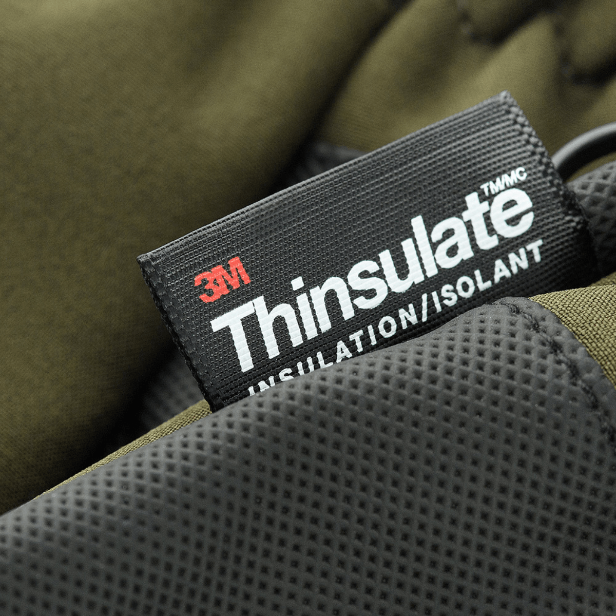 M-Tac Handsker Soft Shell Thinsulate, lähikuva Thinsulate-merkistä oliivinvihreällä taustalla.