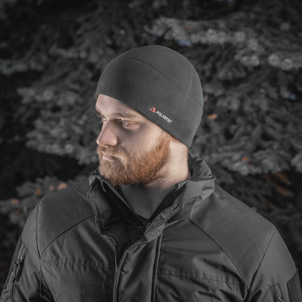 Mies pukeutuneena M-Tac Fleece Watch Cap Light Polartec talvimaisemassa.