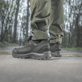 Henkilö pukeutuneena M-Tac Aggressor Summer Flex -housuihin metsässä, näyttää housujen mukavuuden ja kestävyyden luonnollisessa ulkoilumaisemassa.